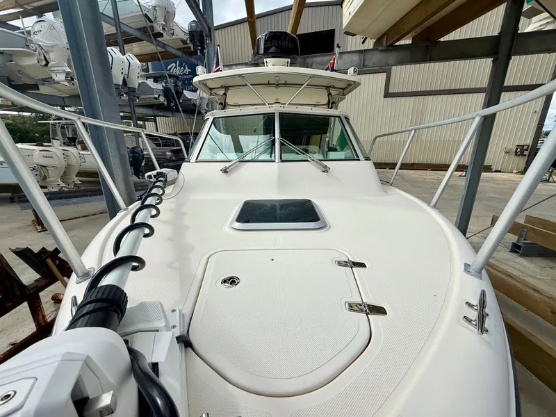 Slide: The Image of 2007 Pursuit 235 Denali LS boat docked in a marina, showcasing its sleek design. - 16