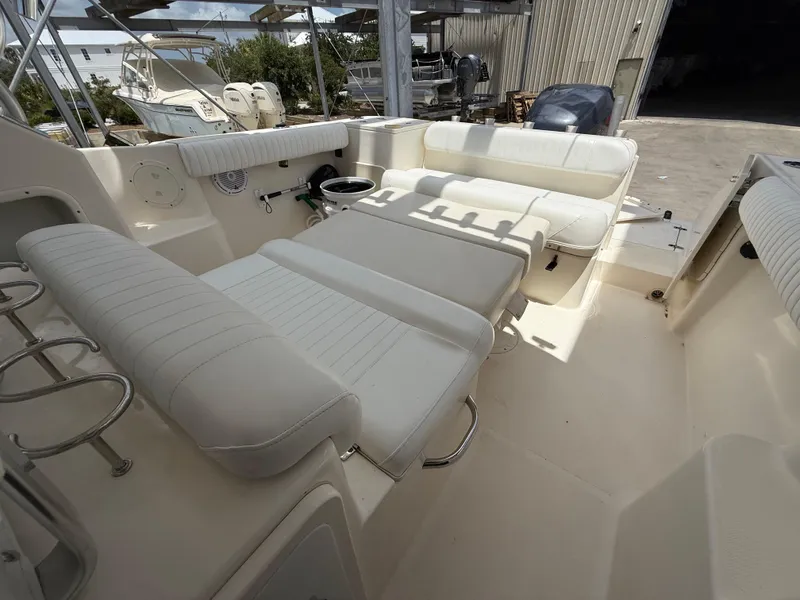 Slide: The Image of 2007 Pursuit 235 Denali LS boat interior with white seating and spacious layout. - 18