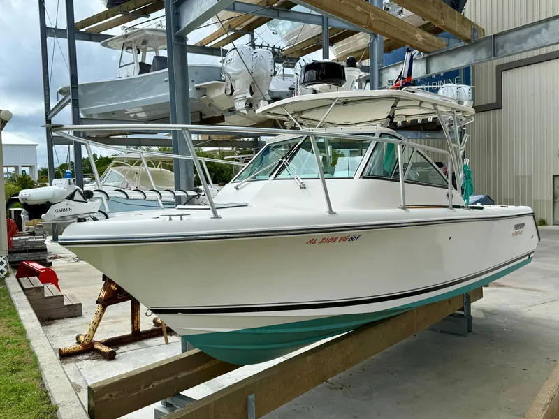 Slide: The Image of 2007 Pursuit 235 Denali LS boat on a lift, with Garmin equipment, in a marina setting. - 2