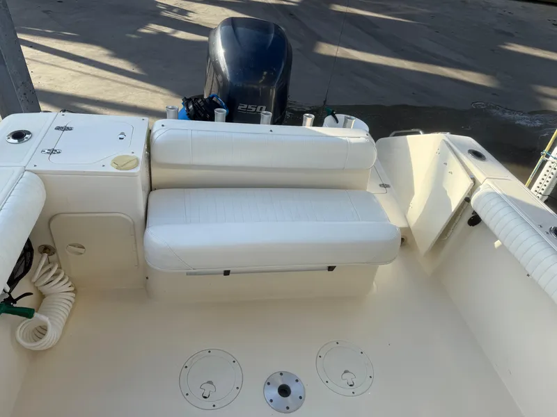 Slide: The Image of 2007 Pursuit 235 Denali LS boat interior with white seating and engine view. - 20