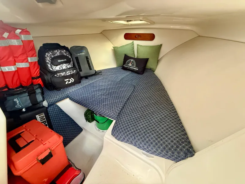 Slide: The Image of Cozy cabin interior of 2007 Pursuit 235 Denali LS with cushions and gear storage. - 22