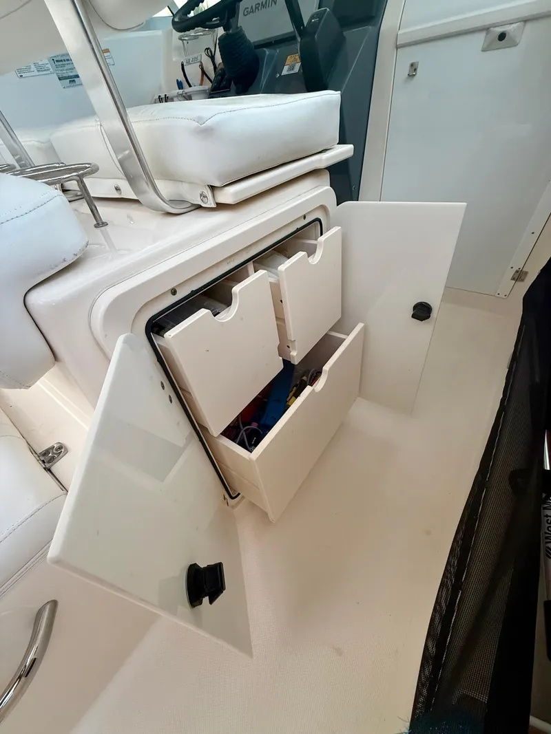 Slide: The Image of 2007 Pursuit 235 Denali LS boat interior with open storage compartment. - 24