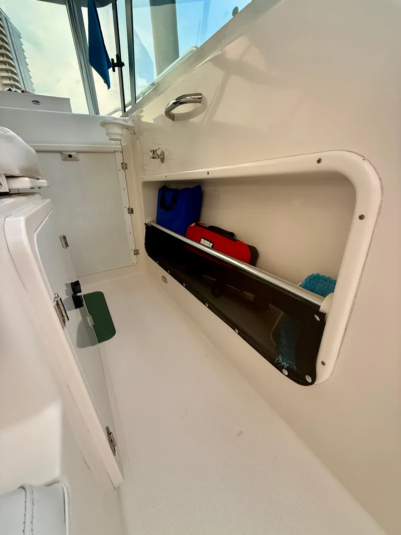 Slide: The Image of 2007 Pursuit 235 Denali LS boat interior storage compartment with gear and accessories. - 27
