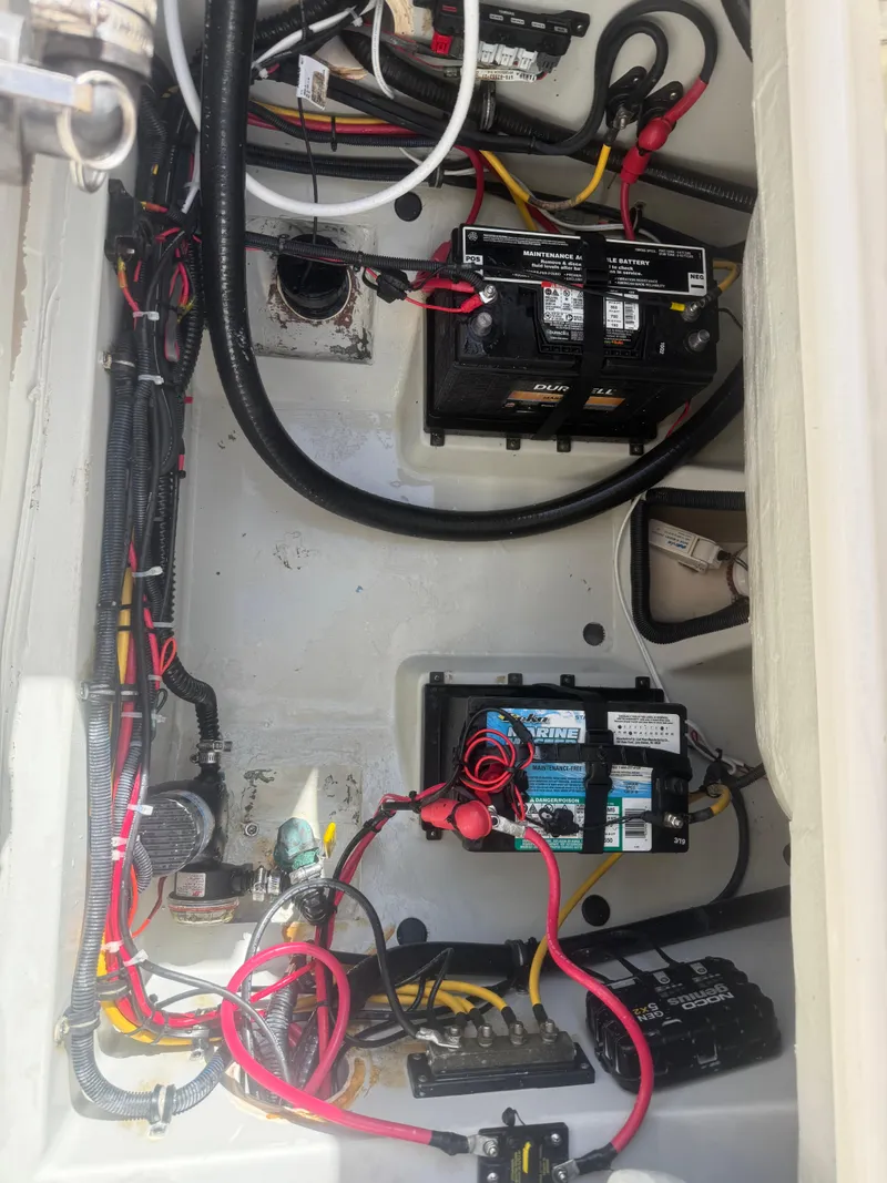 Slide: The Image of 2007 Pursuit 235 Denali LS boat battery compartment with wiring and marine batteries. - 28