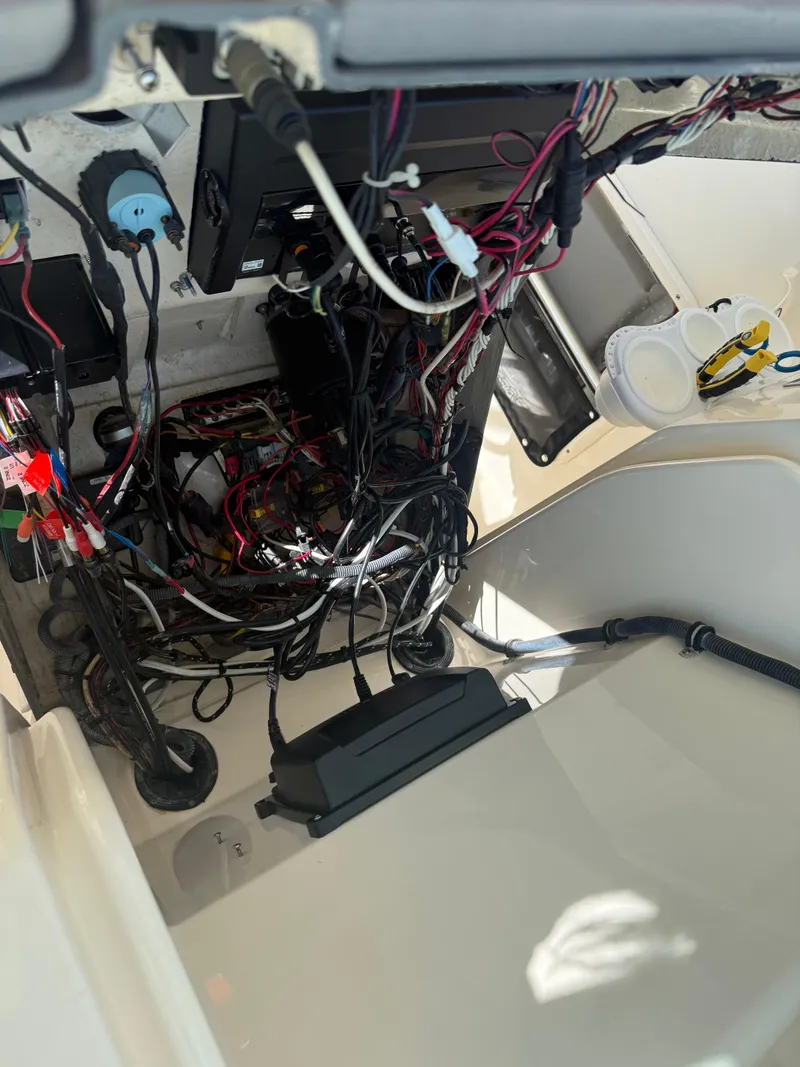 Slide: The Image of Tangled wiring inside a 2007 Pursuit 235 Denali LS boat's electrical compartment. - 30