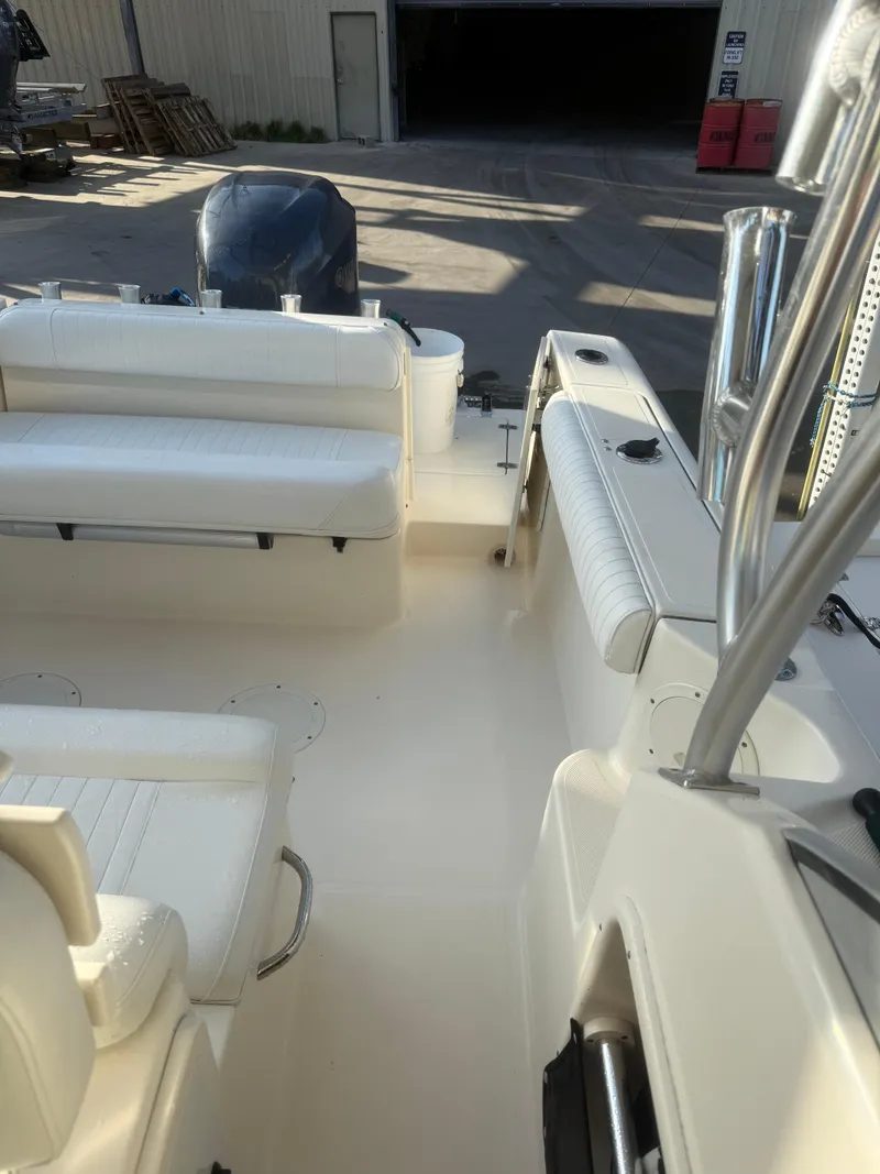 Slide: The Image of 2007 Pursuit 235 Denali LS boat interior with white seating and engine view. - 32