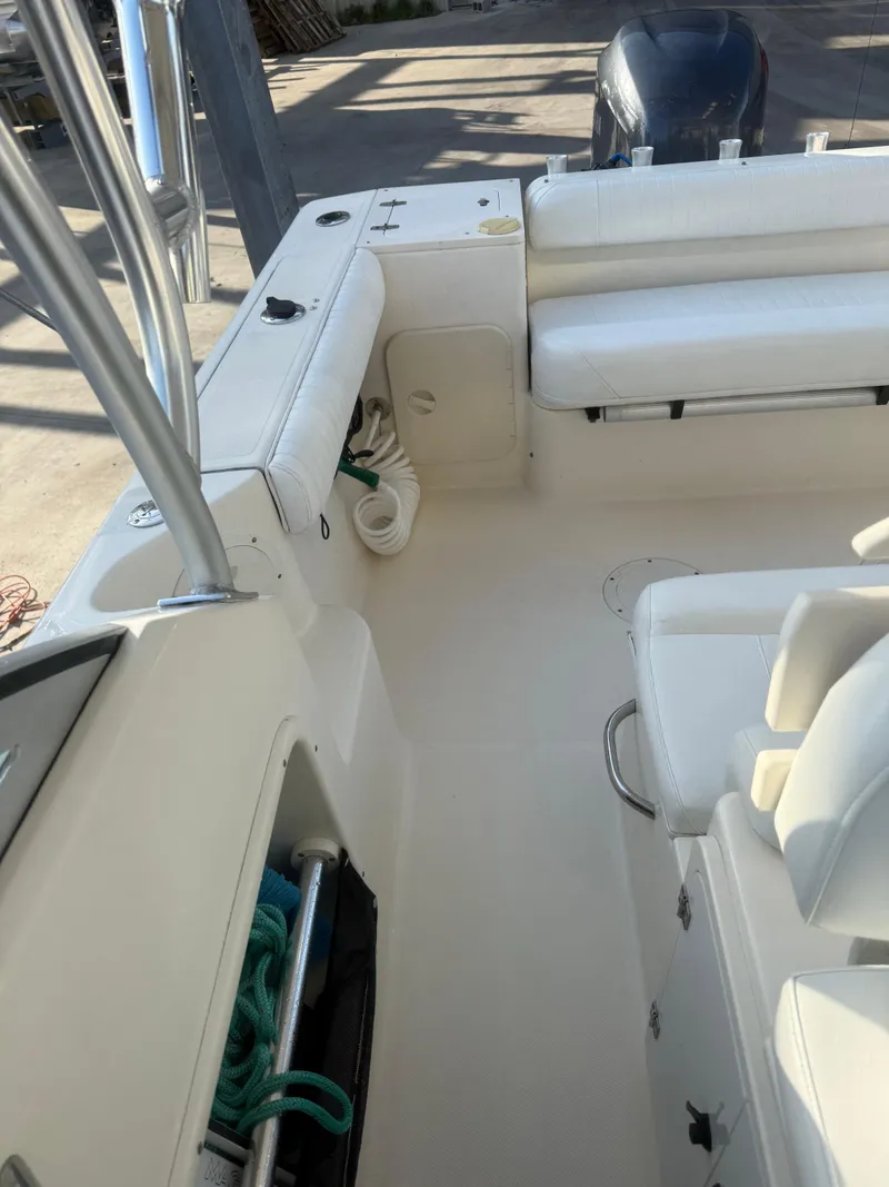 Slide: The Image of 2007 Pursuit 235 Denali LS boat interior with white seating and storage compartments. - 33