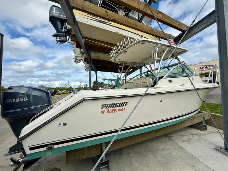 Slide: The Image of 2007 Pursuit 235 Denali LS boat with Yamaha engine on a lift, under a cloudy sky. - 4