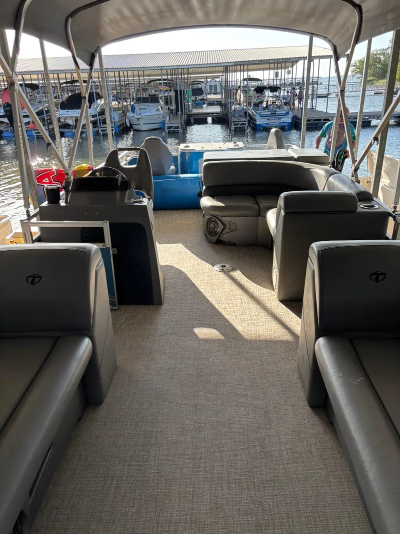 Slide: The Image of 2022 Tahoe Pontoon GT 2585 RF interior with seating, docked at marina. - 8