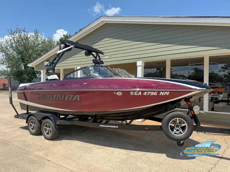 Slide: The Image of 2019 Moomba Craz boat on trailer, parked outside a building on a sunny day. - 0