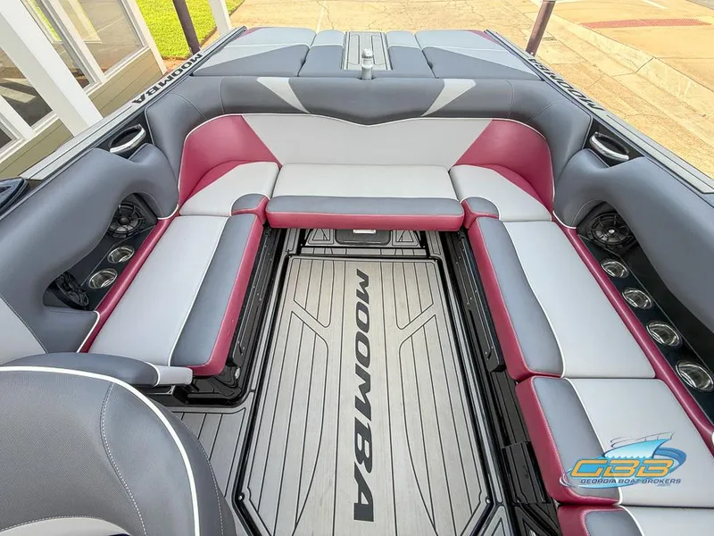 Slide: The Image of 2019 Moomba Craz boat interior with gray and red seating, cup holders, and logo on floor. - 15