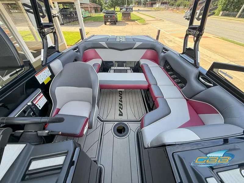 Slide: The Image of 2019 Moomba Craz boat interior with gray and red seating, steering wheel, and deck view. - 16