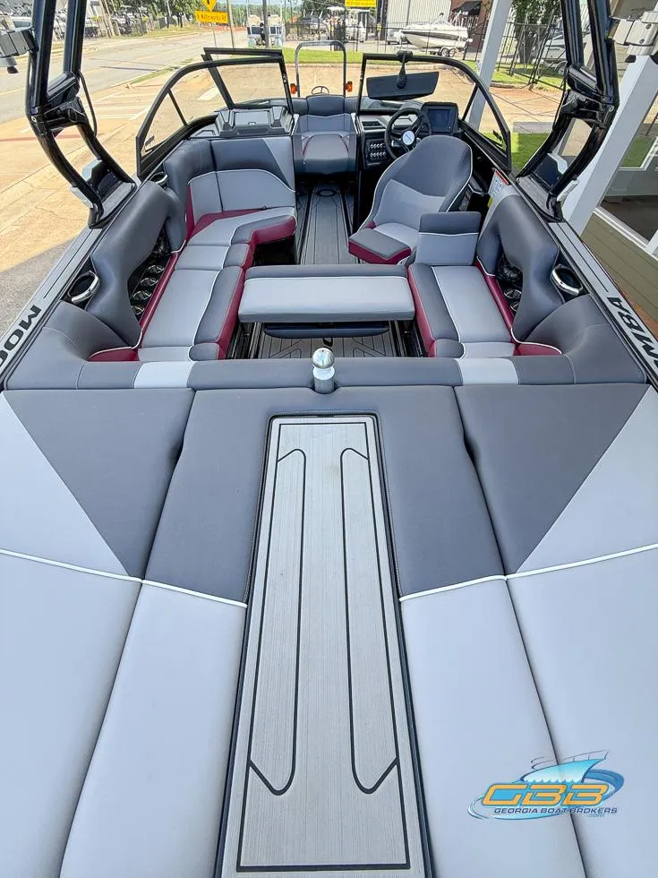 Slide: The Image of 2019 Moomba Craz boat interior with gray and red seating, modern dashboard, and spacious layout. - 20