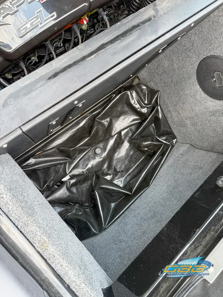 Slide: The Image of 2019 Moomba Craz engine compartment with storage area and black cover. - 24