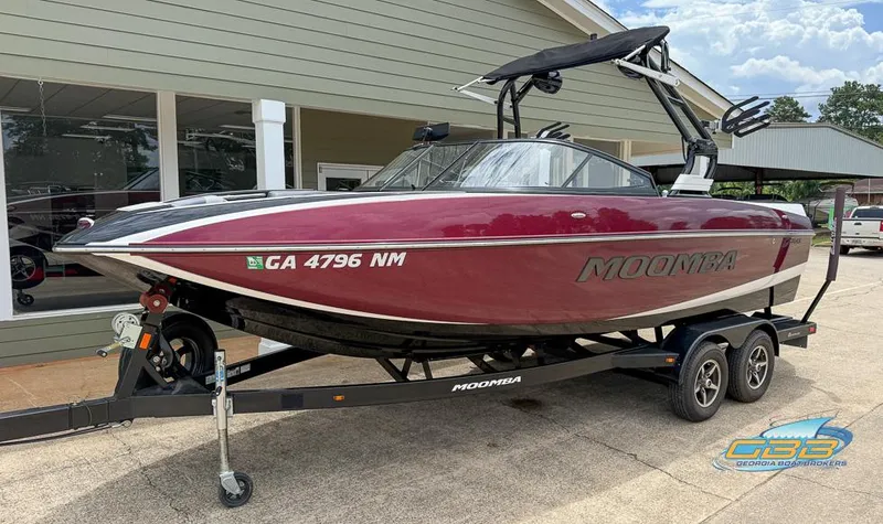 Slide: The Image of 2019 Moomba Craz boat on trailer, maroon color, parked outside a building. - 6