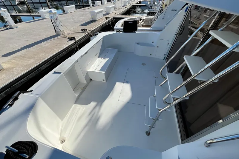 Slide: The Image of 2001 Jefferson International 5300 yacht deck with seating and stairs at marina. - 11
