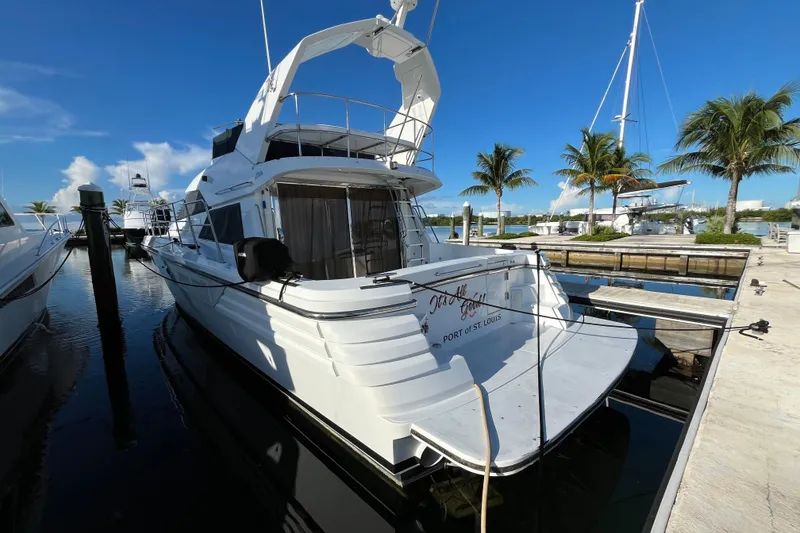 Slide: The Image of 2001 Jefferson International 5300 yacht docked at marina with palm trees and clear blue sky. - 4