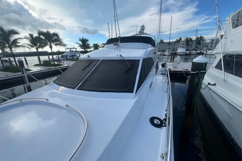 Slide: The Image of 2001 Jefferson International 5300 yacht docked at marina with palm trees and blue sky. - 7