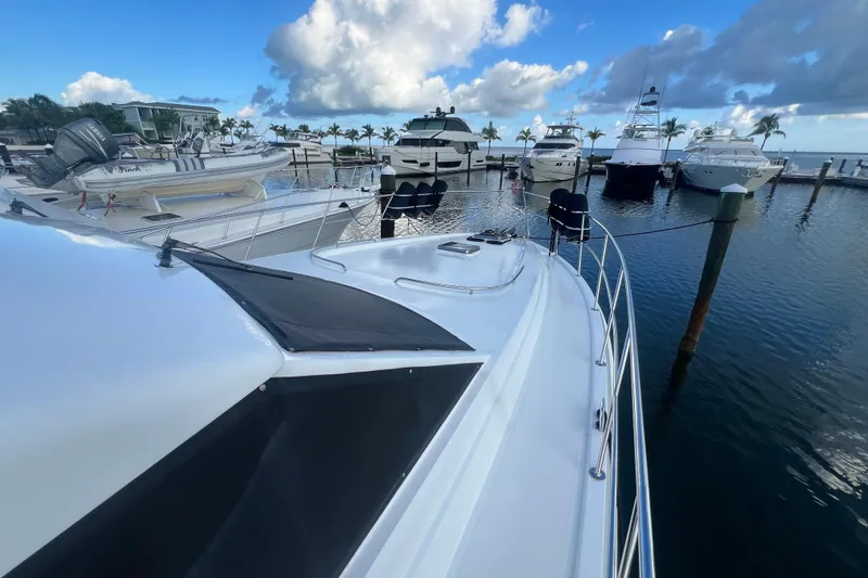 Slide: The Image of 2001 Jefferson International 5300 yacht docked at marina with other boats, under blue sky. - 8