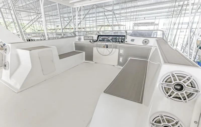 Slide: The Image of 1997 Sumerset 18 x 93 houseboat helm with modern controls and seating in a covered dock. - 19