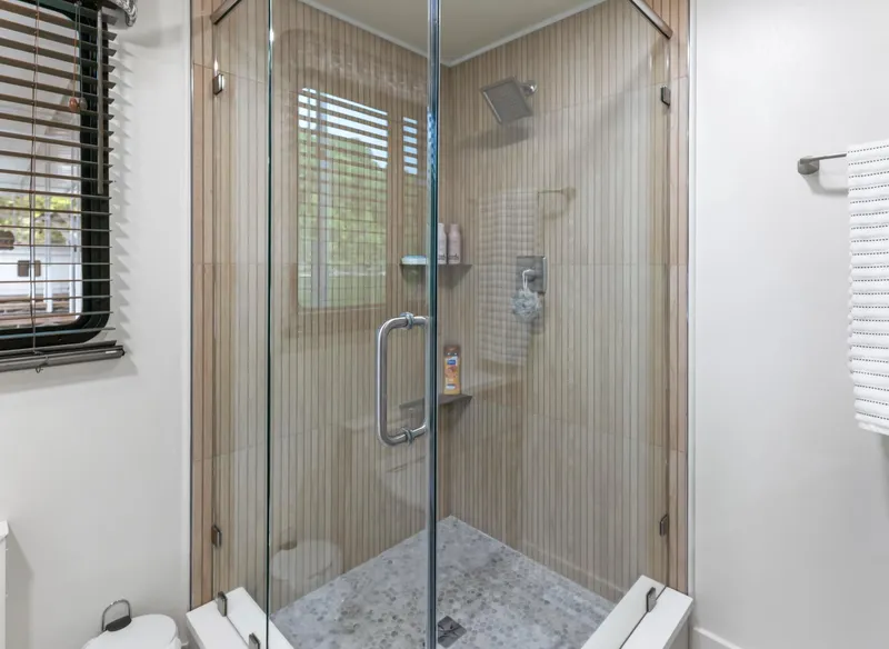 Slide: The Image of Glass-enclosed shower with modern fixtures in a 1997 Sumerset 18 x 93 houseboat bathroom. - 28