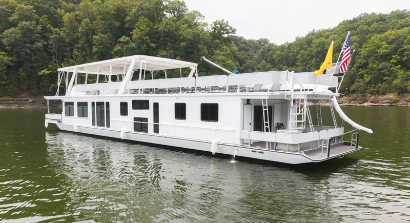 Slide: The Image of 1997 Sumerset 18 x 93 houseboat on a serene lake with lush green forest backdrop. - 3