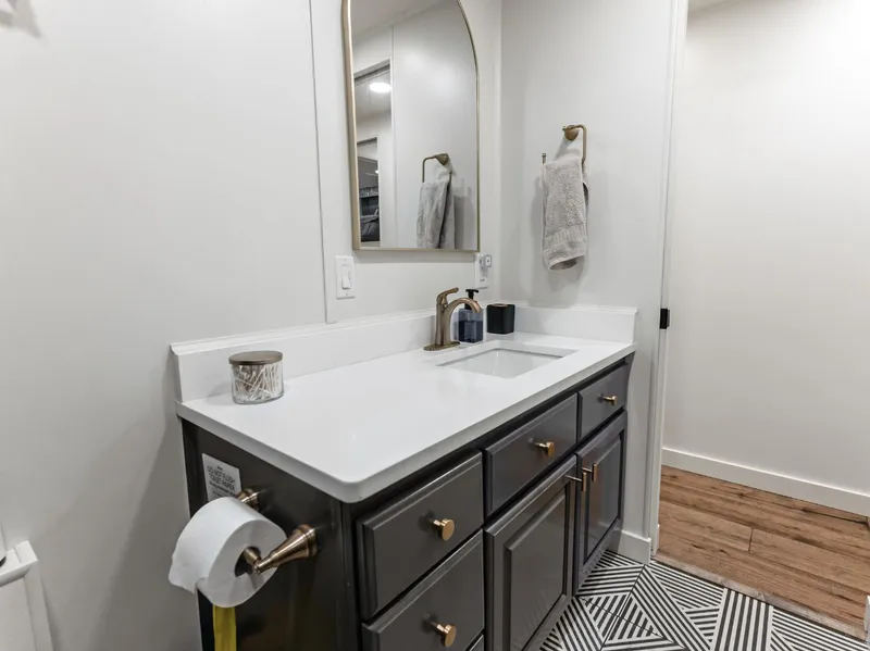 Slide: The Image of Modern bathroom with white countertop, dark cabinets, and geometric floor tiles in a 1997 Sumerset houseboat. - 35