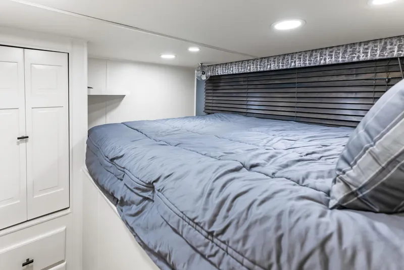 Slide: The Image of Cozy bedroom in 1997 Sumerset 18 x 93 houseboat with blue bedding and modern lighting. - 46