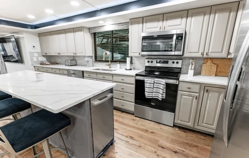 Slide: The Image of Modern kitchen in a 1997 Sumerset 18 x 93 houseboat with stainless steel appliances. - 48