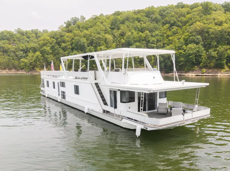 Slide: The Image of 1997 Sumerset 18 x 93 houseboat on a serene lake with lush green forest backdrop. - 6