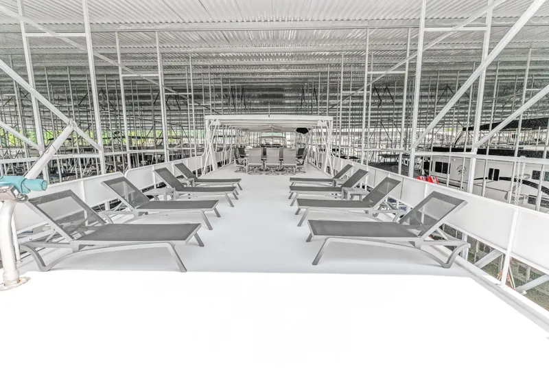 Slide: The Image of Rooftop deck of 1997 Sumerset 18 x 93 houseboat with lounge chairs under covered dock. - 9