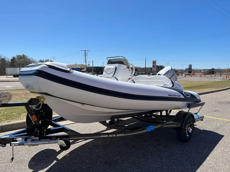 Slide: The Image of 2022 Walker Bay Venture 14 boat on trailer under clear blue sky. - 16