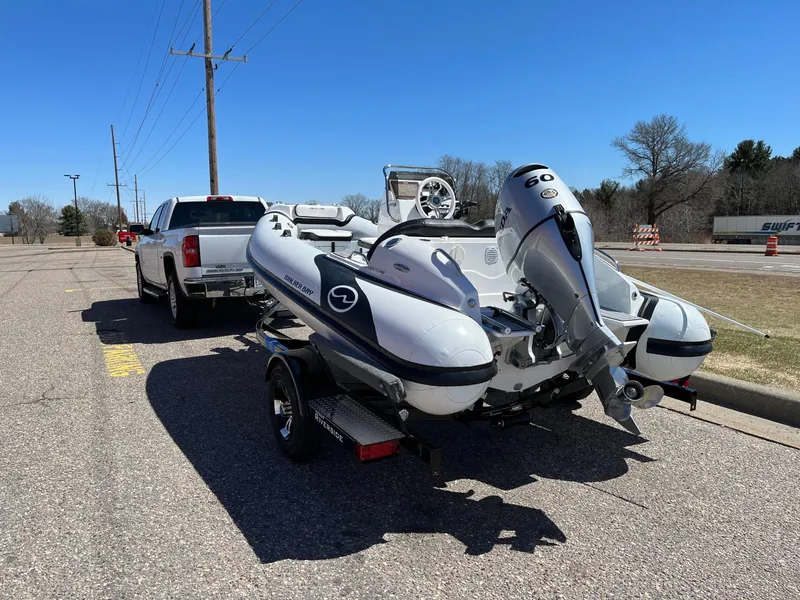 Slide: The Image of 2022 Walker Bay Venture 14 boat on trailer, hitched to a white truck in a parking lot. - 21