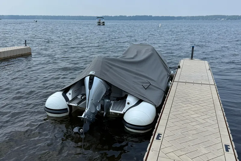 Slide: The Image of 2022 Walker Bay Venture 14 boat covered at dockside on a calm lake. - 25