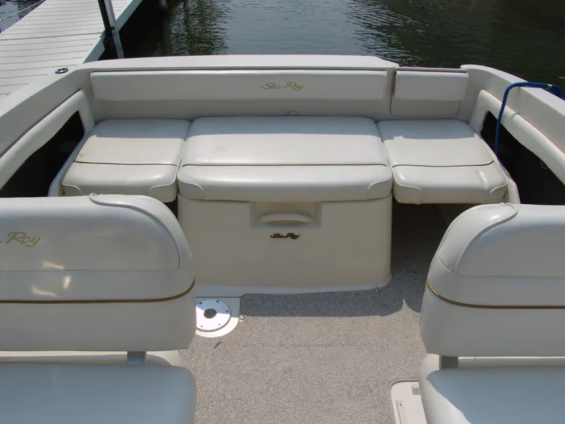 Slide: The Image of 2000 Sea Ray 215 Express Cruiser interior with white seating and water view. - 10