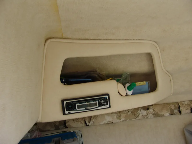 Slide: The Image of Interior storage compartment of 2000 Sea Ray 215 Express Cruiser with radio and items. - 18