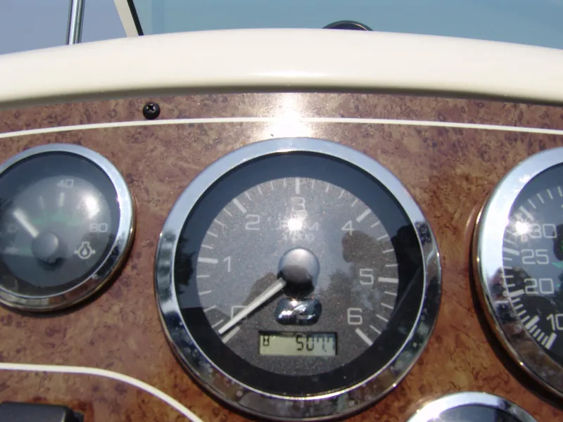 Slide: The Image of Dashboard of a 2000 Sea Ray 215 Express Cruiser with gauges and RPM display. - 8