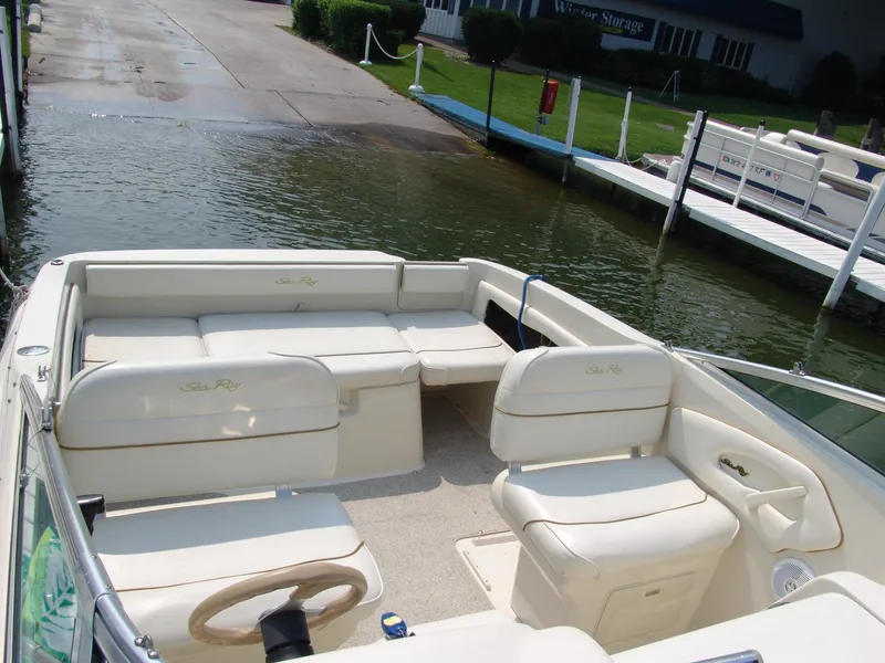 Slide: The Image of 2000 Sea Ray 215 Express Cruiser interior with beige seating at dock. - 9