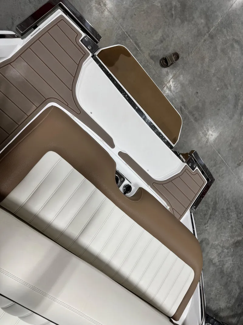 Slide: The Image of 2015 Cobalt 24 SD boat interior with brown and white seating. - 11