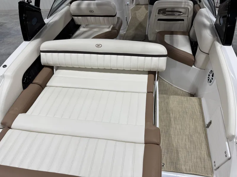 Slide: The Image of 2015 Cobalt 24 SD boat interior with white and brown seating, spacious layout. - 12