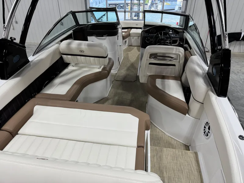 Slide: The Image of 2015 Cobalt 24 SD boat interior with beige and white seating, steering wheel, and carpeted floor. - 6