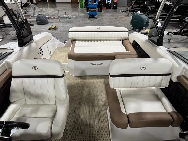 Slide: The Image of 2015 Cobalt 24 SD boat interior with white and brown seating in a showroom. - 7