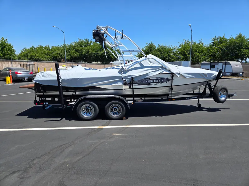 Slide: The Image of 2007 Centurion Air Warrior Elite V-Drive C4 boat on trailer, covered, in parking lot. - 4