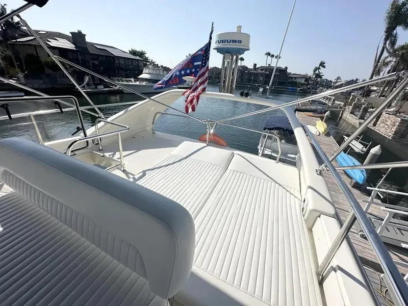 Slide: The Image of 1996 Azimut 54 yacht deck with American flag, docked in a marina. - 11