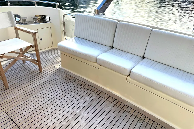 Slide: The Image of Deck seating area on a 1996 Azimut 54 yacht with white cushions and wooden flooring. - 12