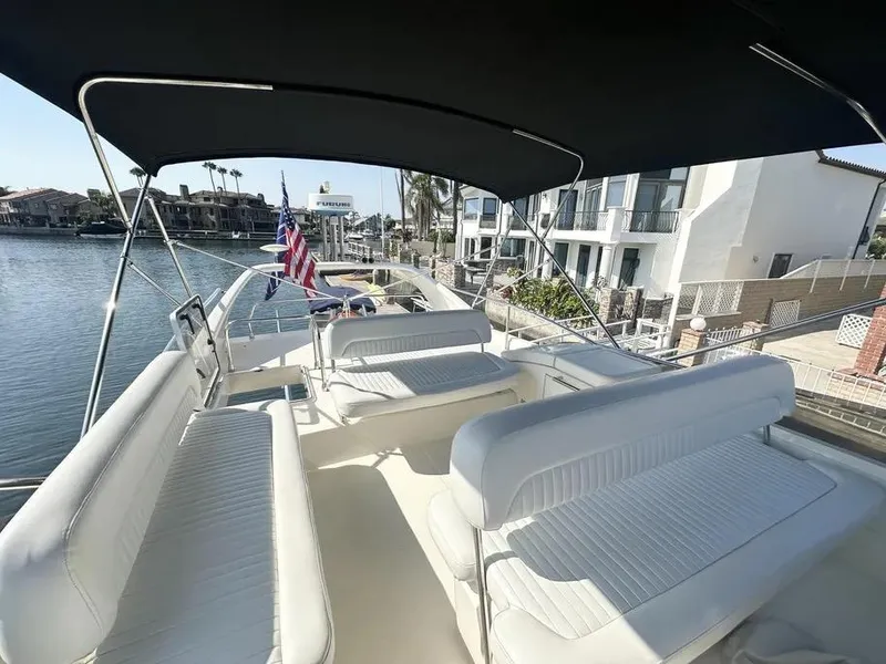 Slide: The Image of 1996 Azimut 54 yacht with spacious seating, docked near waterfront homes. - 15