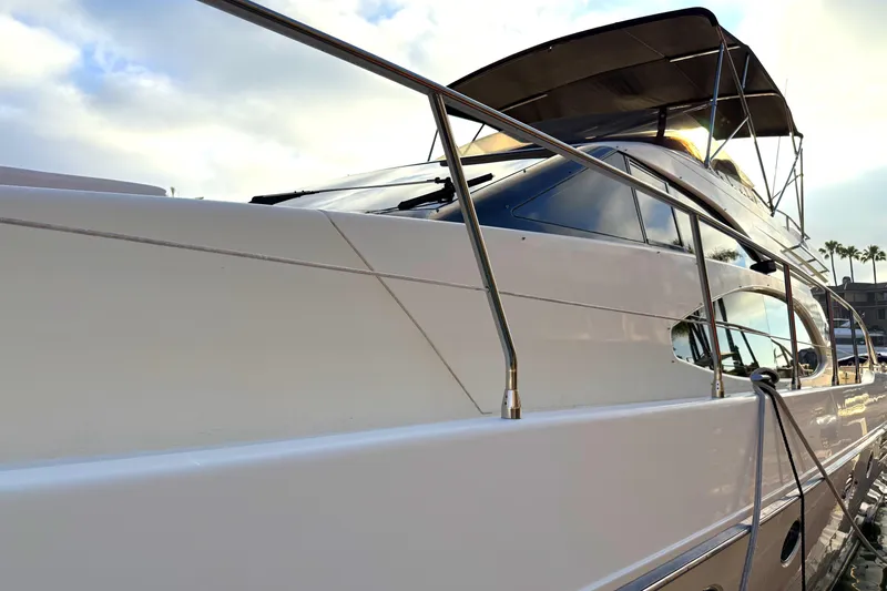 Slide: The Image of 1996 Azimut 54 yacht with sleek design, docked under a cloudy sky. - 2