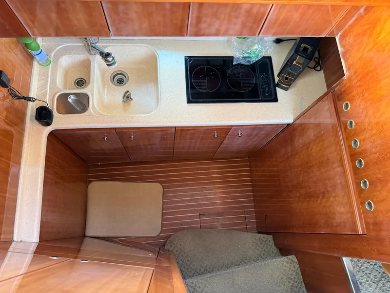 Slide: The Image of Kitchen area of a 1996 Azimut 54 yacht with wooden cabinetry and modern appliances. - 22