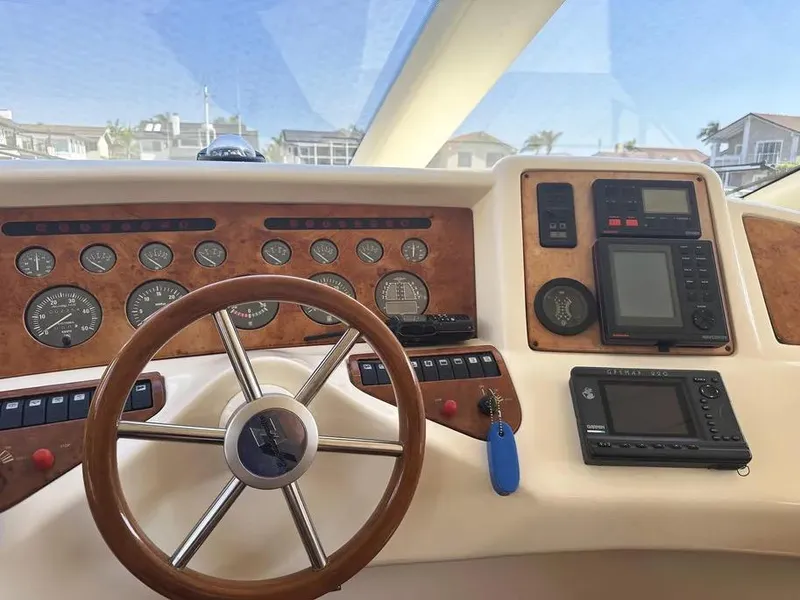 Slide: The Image of 1996 Azimut 54 yacht dashboard with wooden steering wheel and navigation instruments. - 29