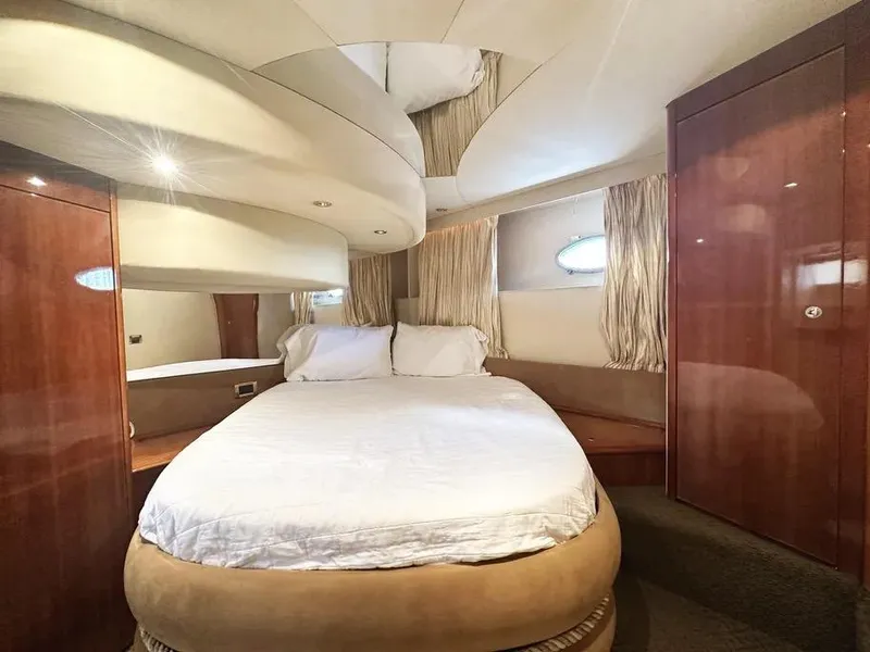 Slide: The Image of Luxurious bedroom interior of a 1996 Azimut 54 yacht with elegant wood finishes. - 42